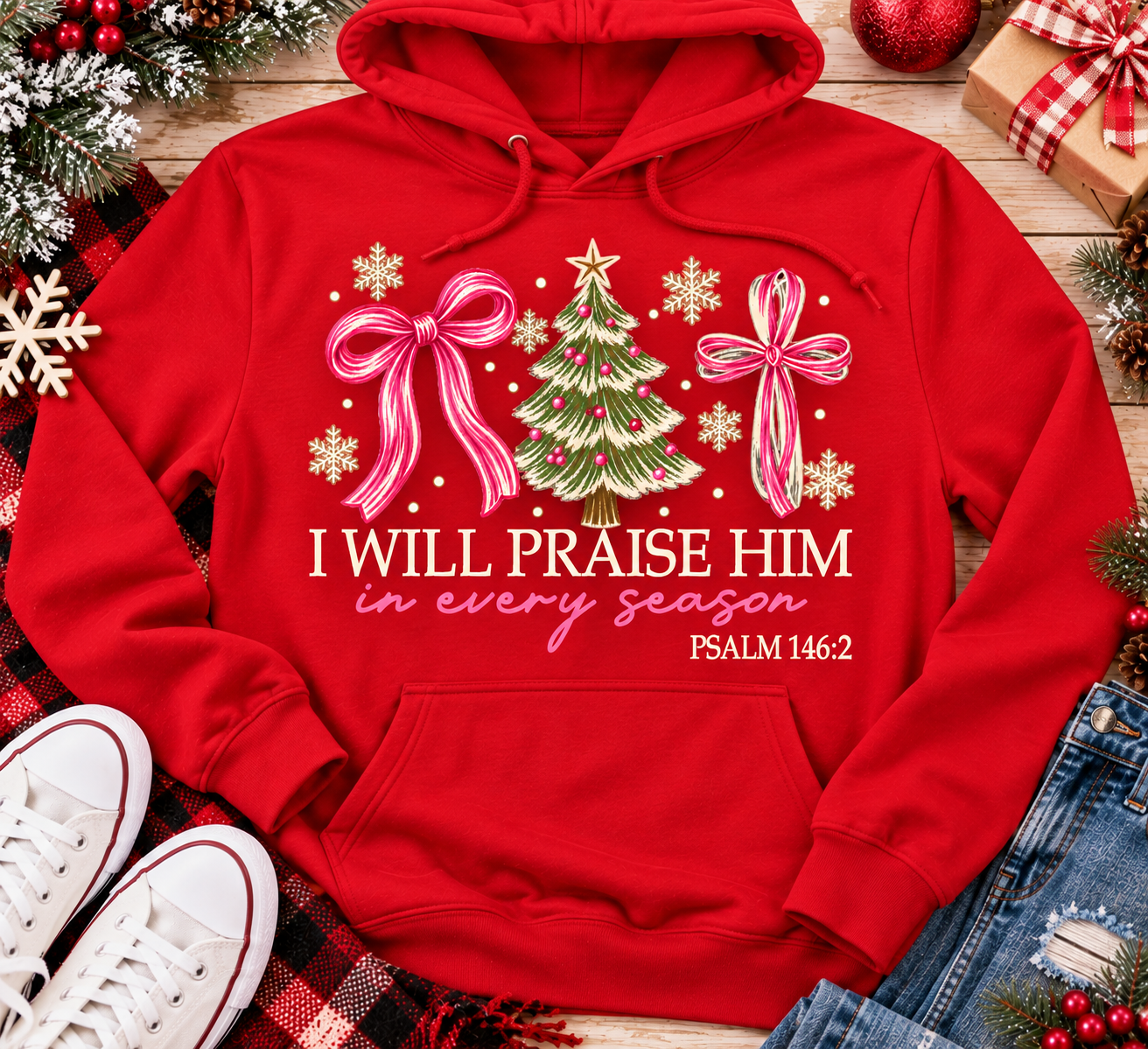 Christian Christmas shirt featuring I Will Praise Him in Every Season Psalm 146:2 graphic with pink bows, decorated Christmas tree, and cream snowflakes.
