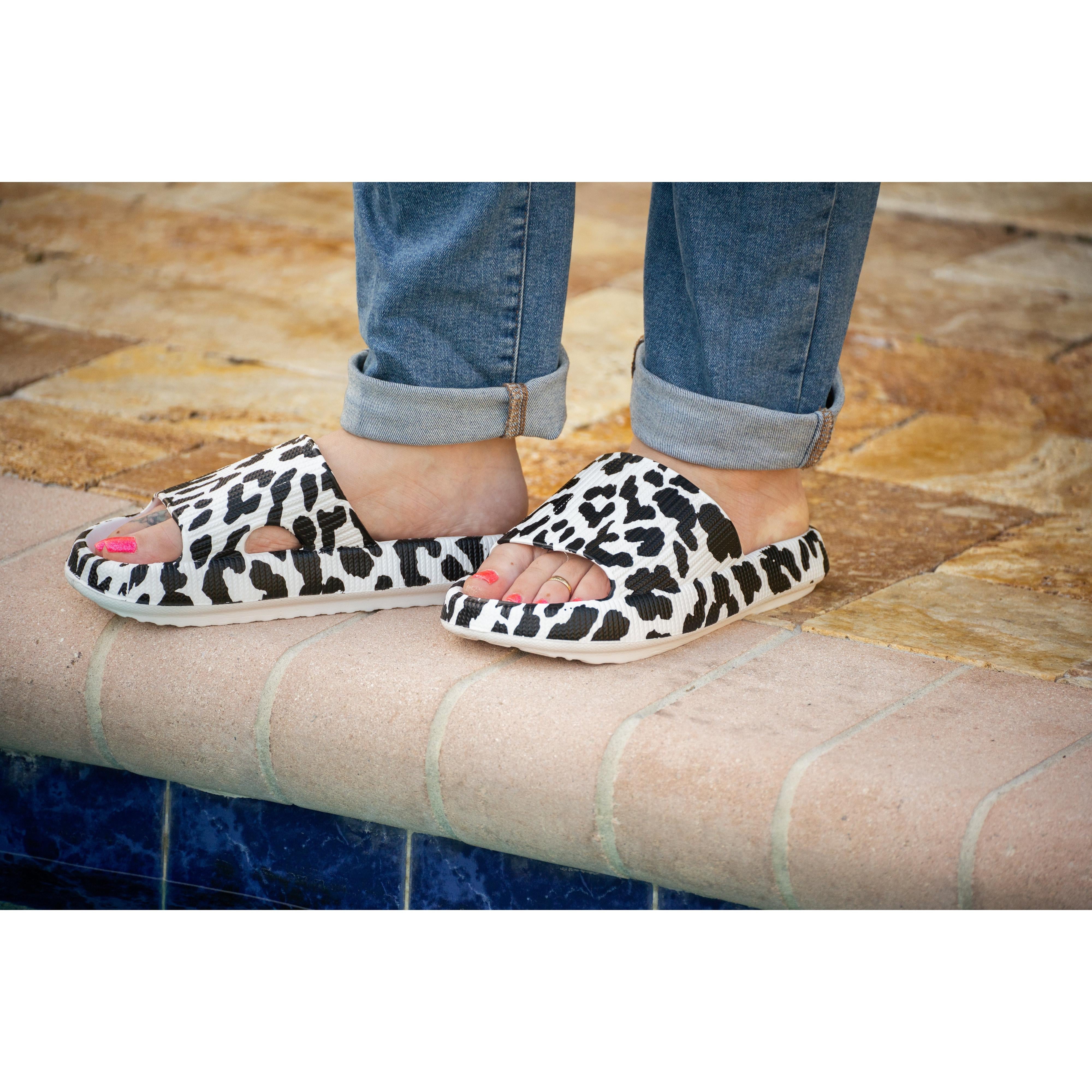 White leopard-print beach slides with a bold spotted pattern and easy slip-on design