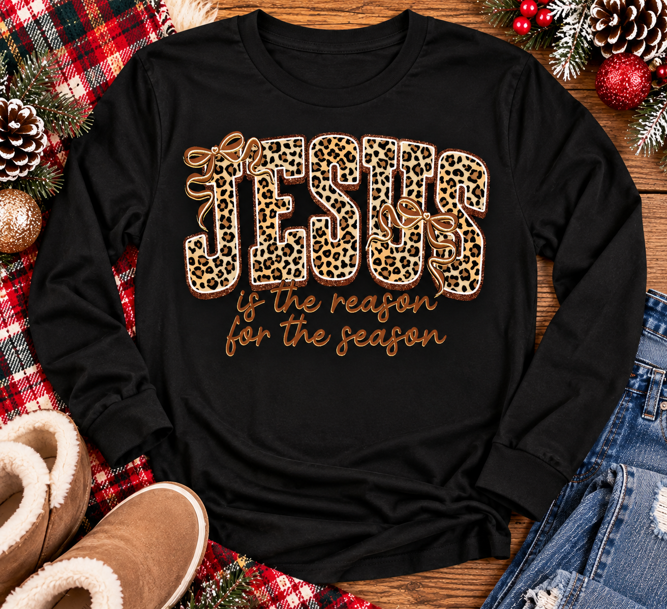 Jesus Is the Reason for the Season Christmas graphic shirt featuring bold leopard print JESUS lettering, decorative gold bows, and gold script. Faith-inspired holiday apparel available in red and black with four style options.