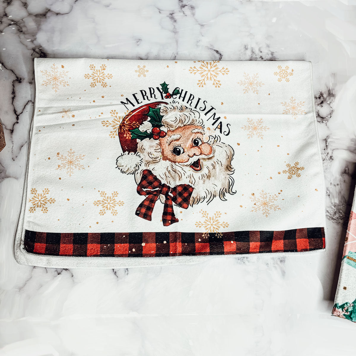 Festive kitchen towel with gold snowflakes and Santa Claus print
Classic Christmas dish towel with red and black gingham border
Nostalgic Santa kitchen towel for holiday decor inspiration