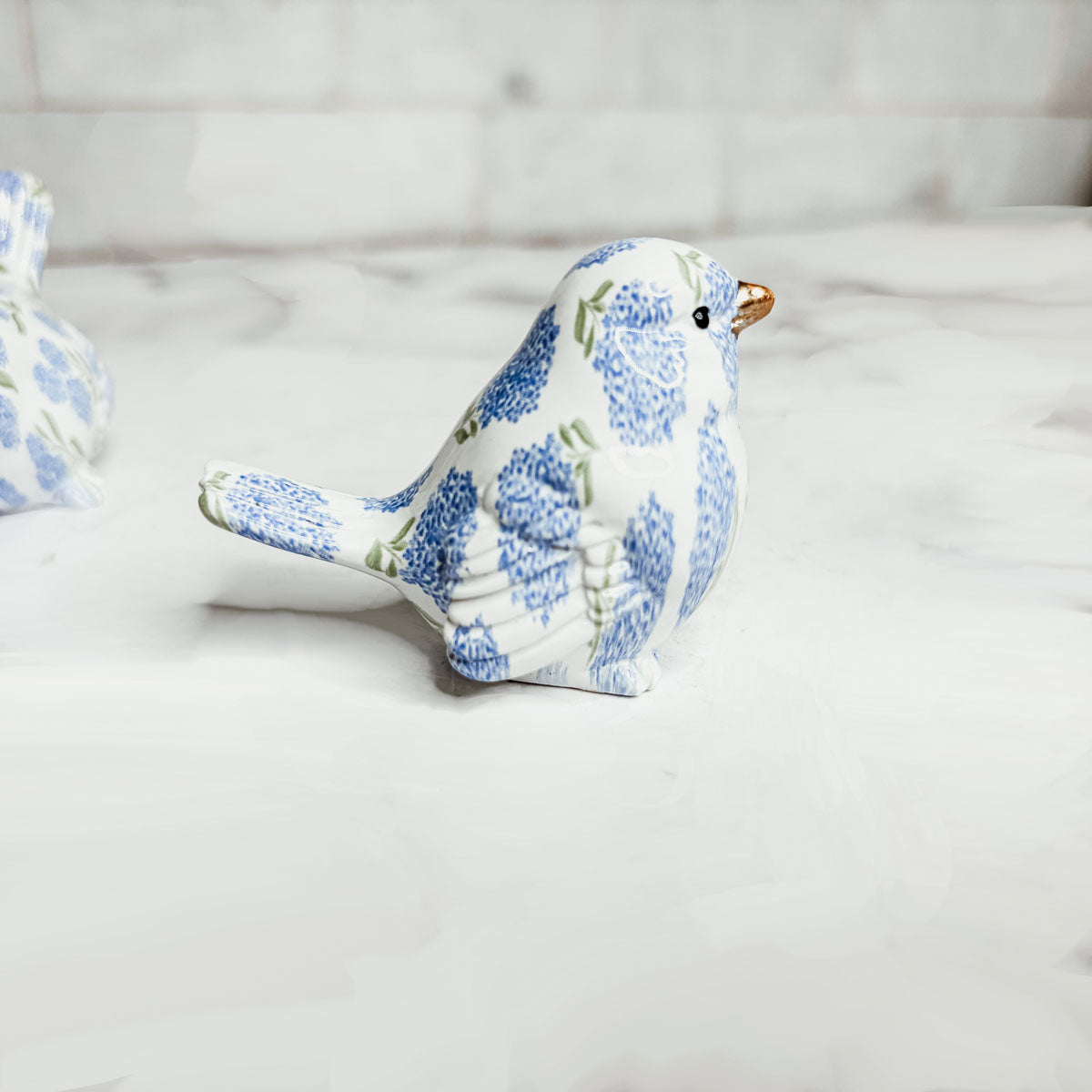 Side view of blue hydrangea bird figurine, highlighting its elegant design and vibrant colors