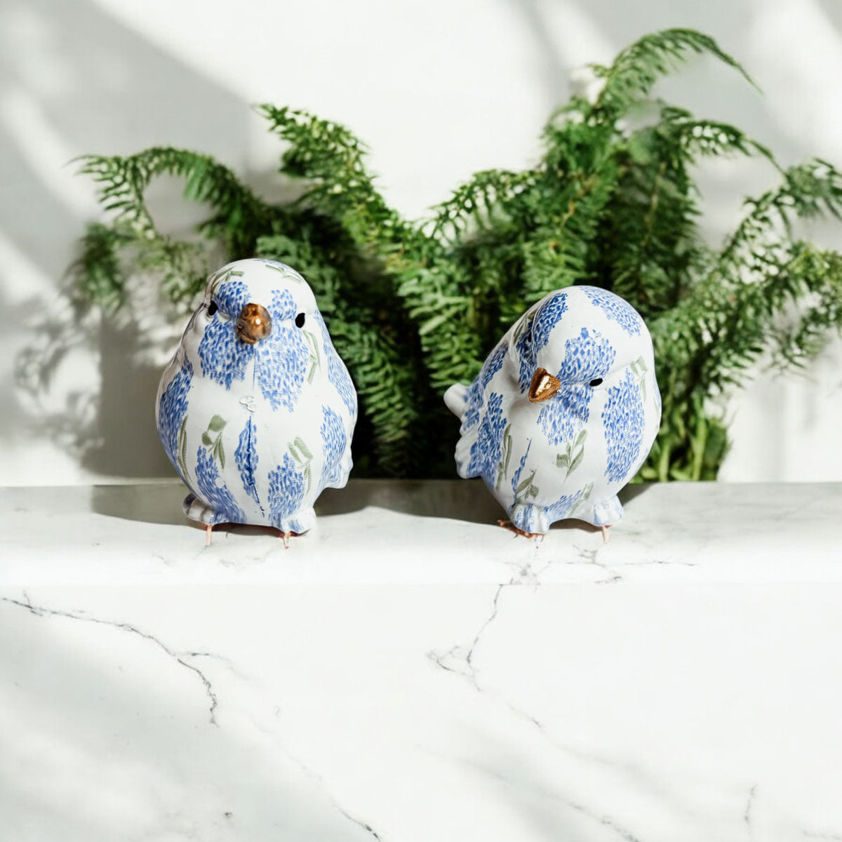 Decorative resin bird figurines featuring blue hydrangea designs, adding elegance to any space