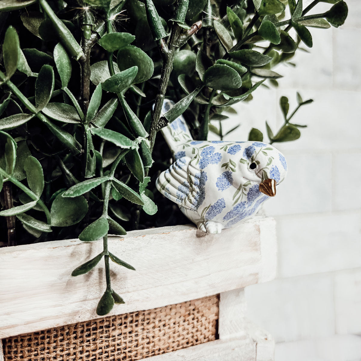 Blue hydrangea bird figurine displayed on a mantel, adding a touch of nature to indoor spaces