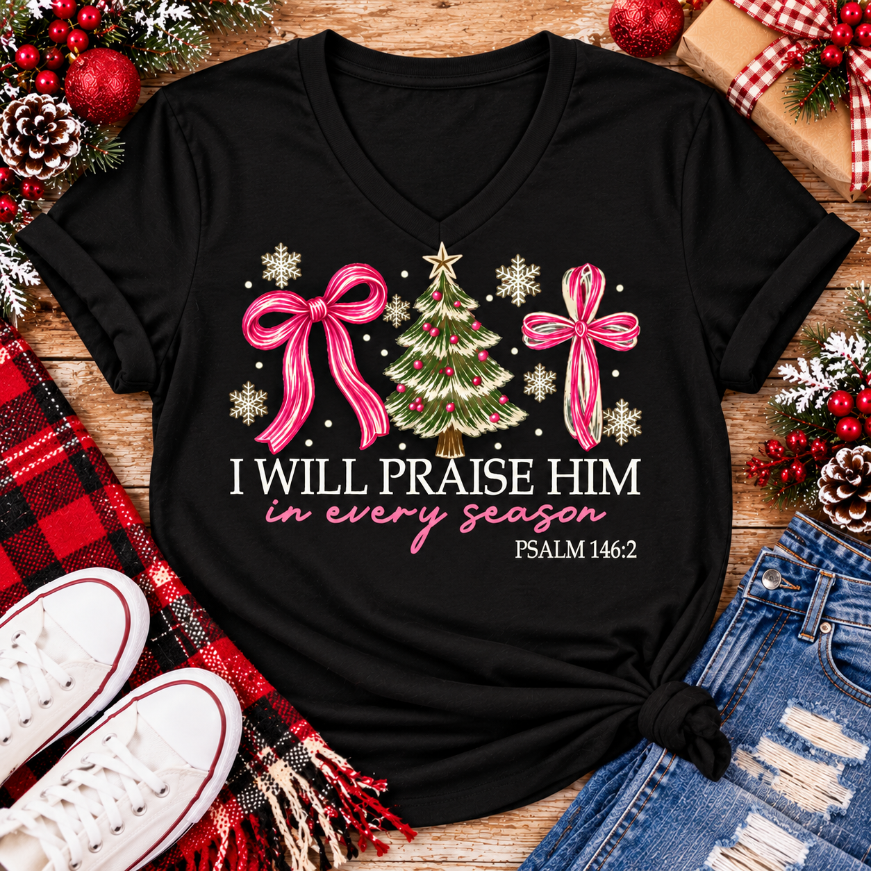 Christian Christmas shirt featuring I Will Praise Him in Every Season Psalm 146:2 graphic with pink bows, decorated Christmas tree, and cream snowflakes.