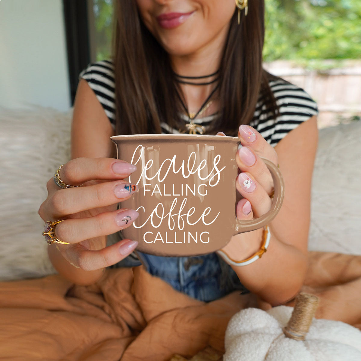 leaves falling coffee calling cup with pumpkin bread
fall countertop decor featuring brown quote mug
autumn coffee bar setup with leaves and coffee mug
brown fall mug styled with beads and greenery
leaves falling coffee calling mug by lit fall candle